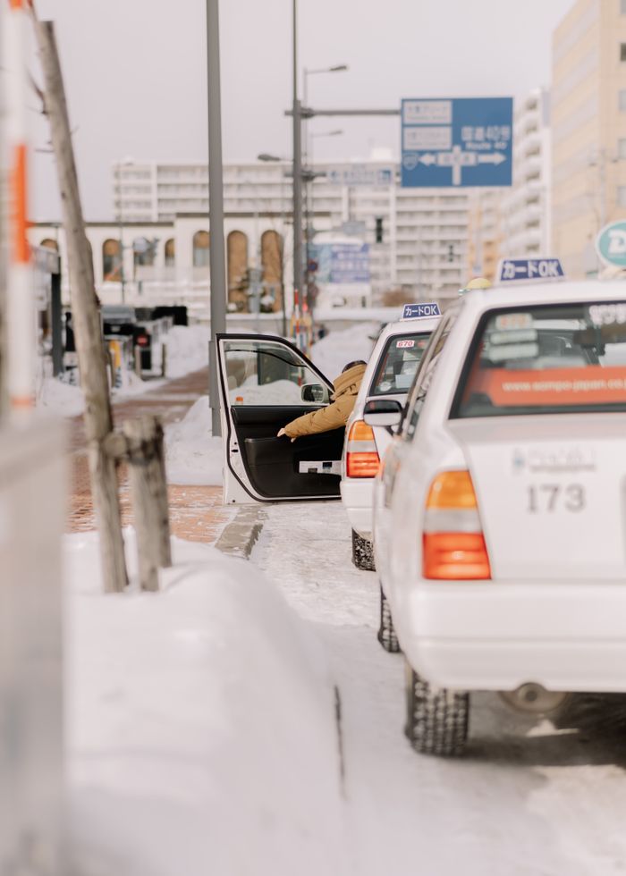 Taxis line a snowy street in Asahikawa, capturing urban winter life in Hokkaido, Japan.